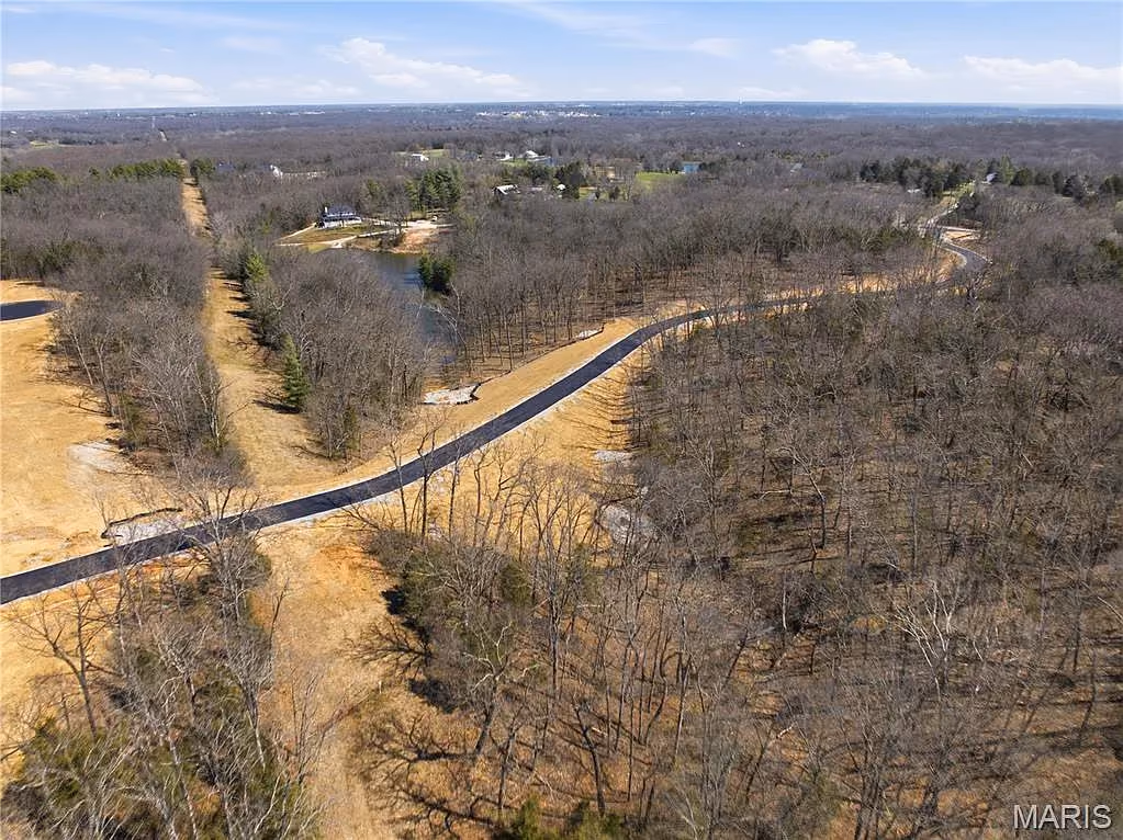 Two community roads meeting among wooded homesites