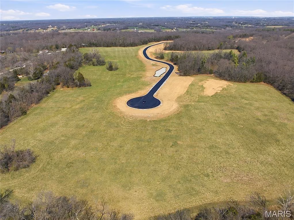 Winding drive ending in a cul-de-sac within an open meadow homesite